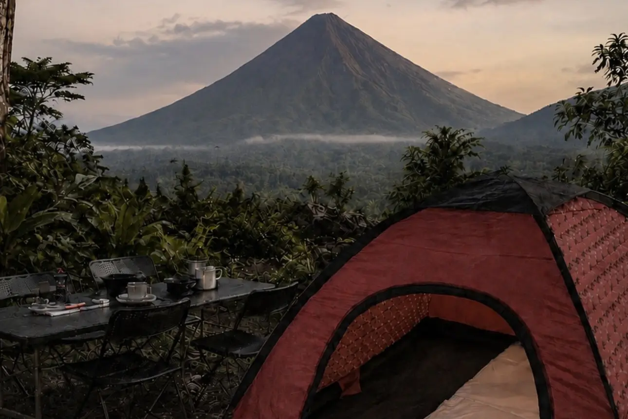 Persona en kayak que rema por una laguna verde hacia colinas cubiertas de bosque y el volcán Arenal